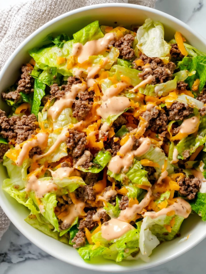 A bowl of salad with cheese and dressing.