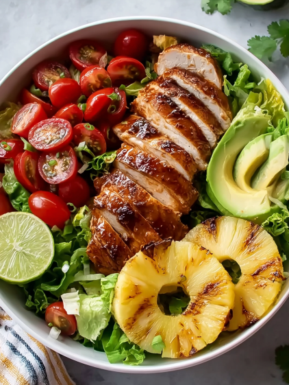 A bowl of chicken salad with pineapple and avocado.
