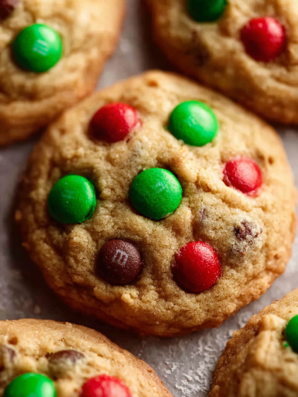A close up of a cookie with green and red m&m's.