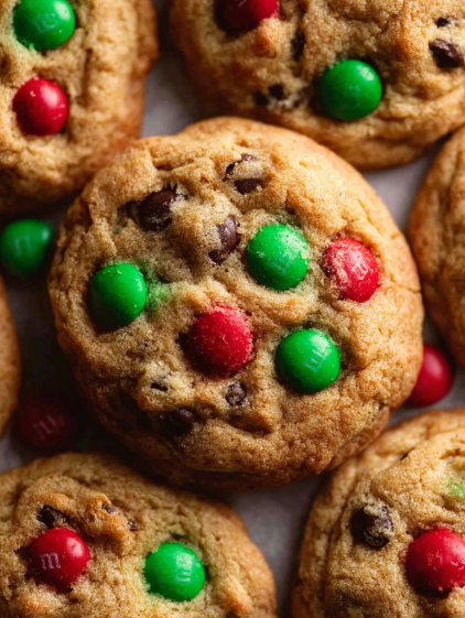 A close up of a chocolate chip cookie with green and red sprinkles.