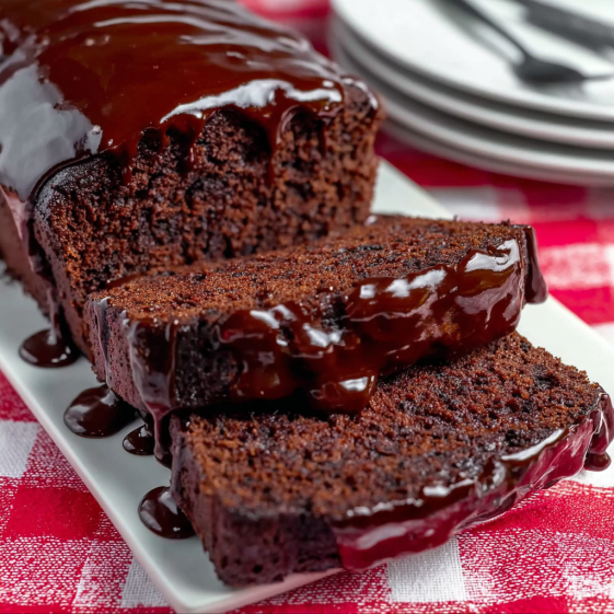 A slice of chocolate cake with chocolate sauce.