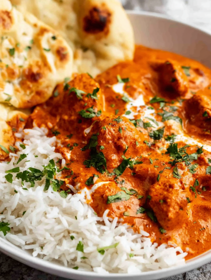 A plate of food with rice, chicken, and sauce.