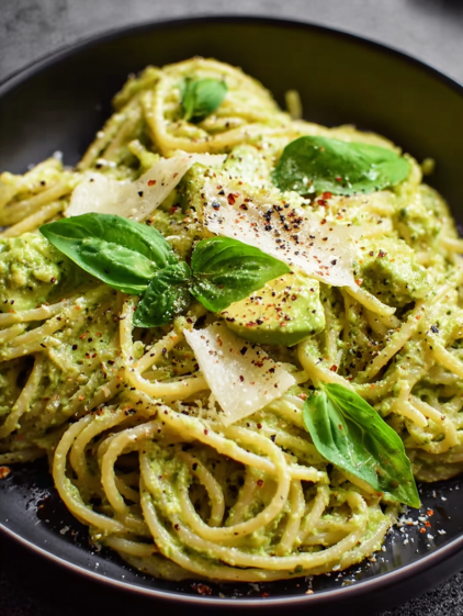 A bowl of pasta with green leaves on top.