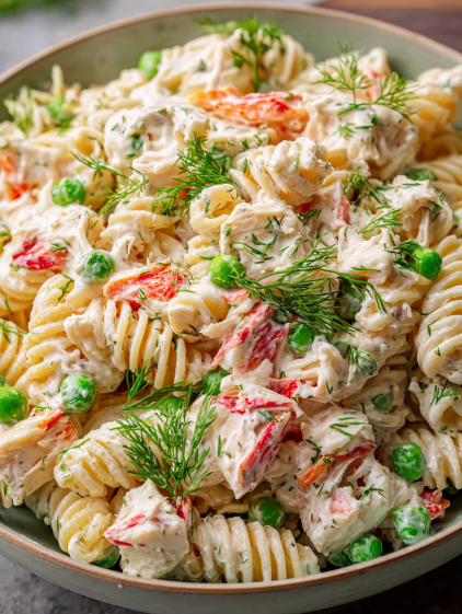 A bowl of pasta with chicken and peas.