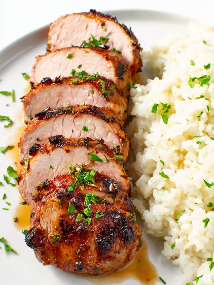 A piece of meat with rice and green herbs.