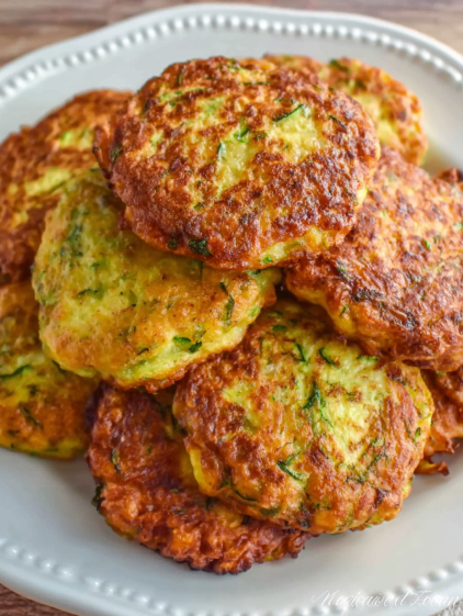 A stack of pancakes with green toppings.