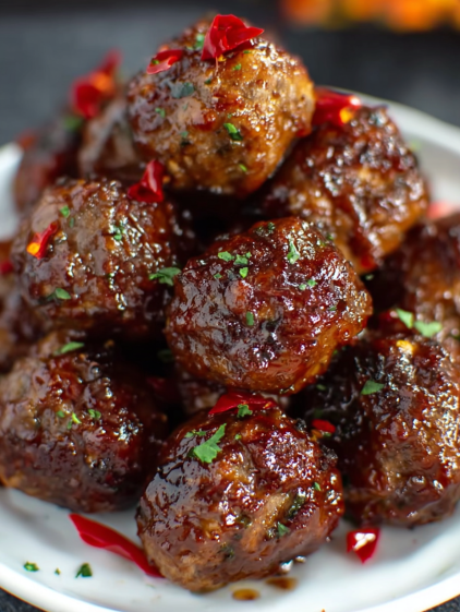 A plate of meatballs with sauce.