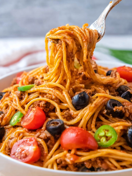 A plate of spaghetti with meatballs and tomatoes.