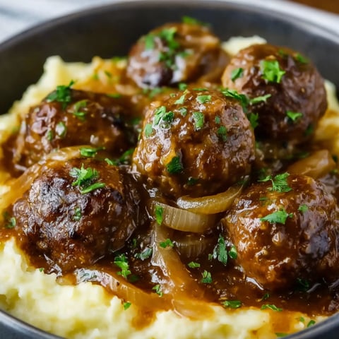 A bowl of meatballs and onions.