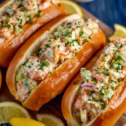 A plate of shrimp rolls with lemon wedges on the side.