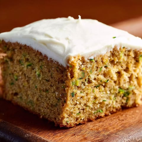 A slice of cake with cream cheese frosting.