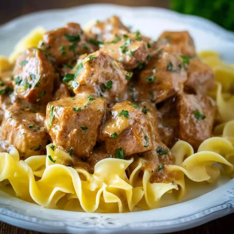 A plate of pork bites with gravy.