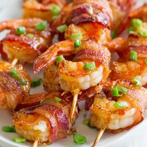 Bacon wrapped shrimp on a plate.