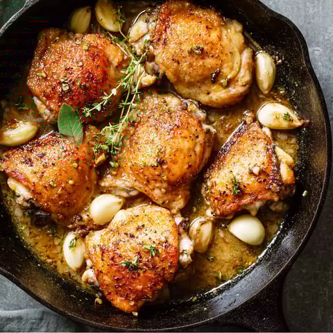 A pan of chicken with garlic and herbs.