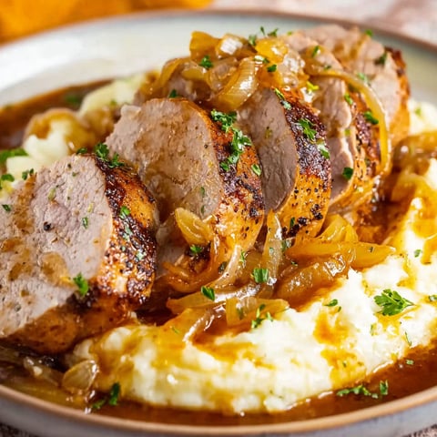 A plate of food with a pork tenderloin and onions.