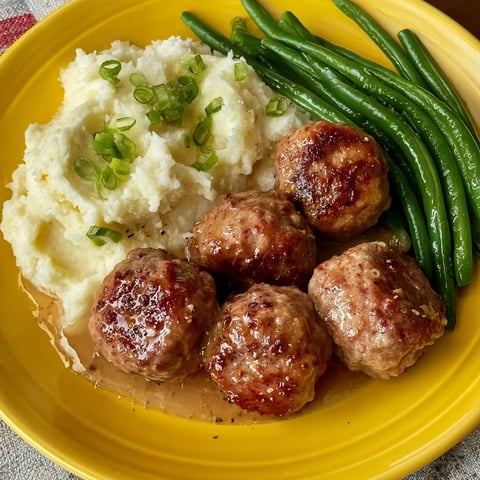 A plate of food with meatballs and green beans.