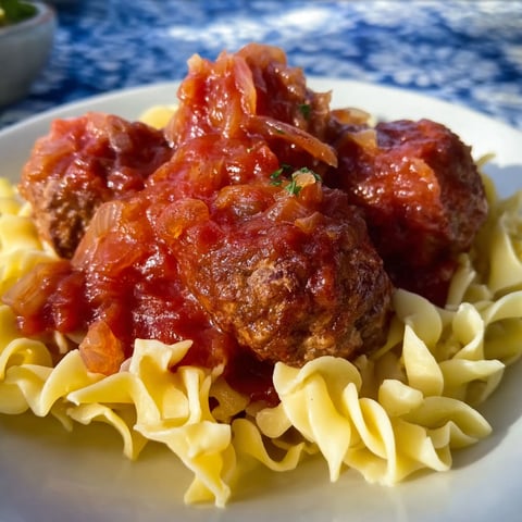 A plate of meatballs covered in sauerkraut.