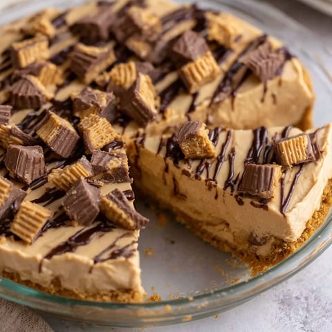 A slice of peanut butter pie with chocolate drizzled on top.
