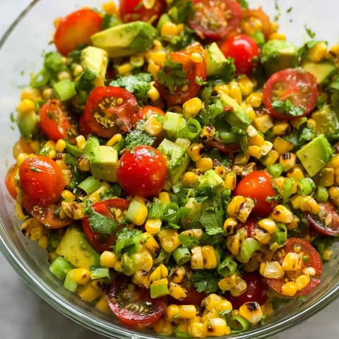 A bowl of roasted corn salad with avocado.
