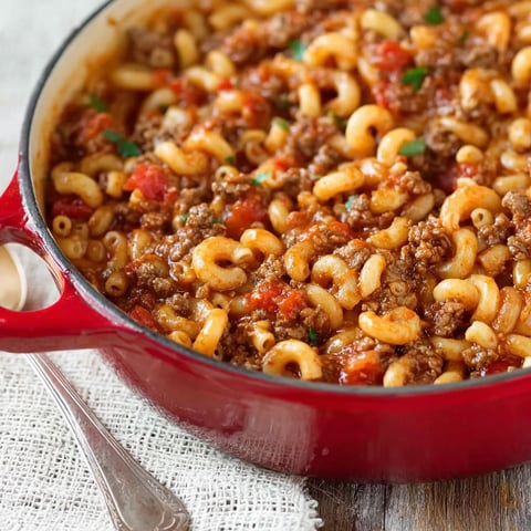 A red pot filled with a goulash meal.